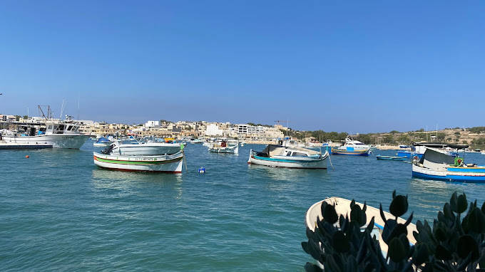 CFresh seafood and Mediterranean cuisine served at Harbour by Johann restaurant in Marsaxlokk, Malta, with a view of the bustling fish market.