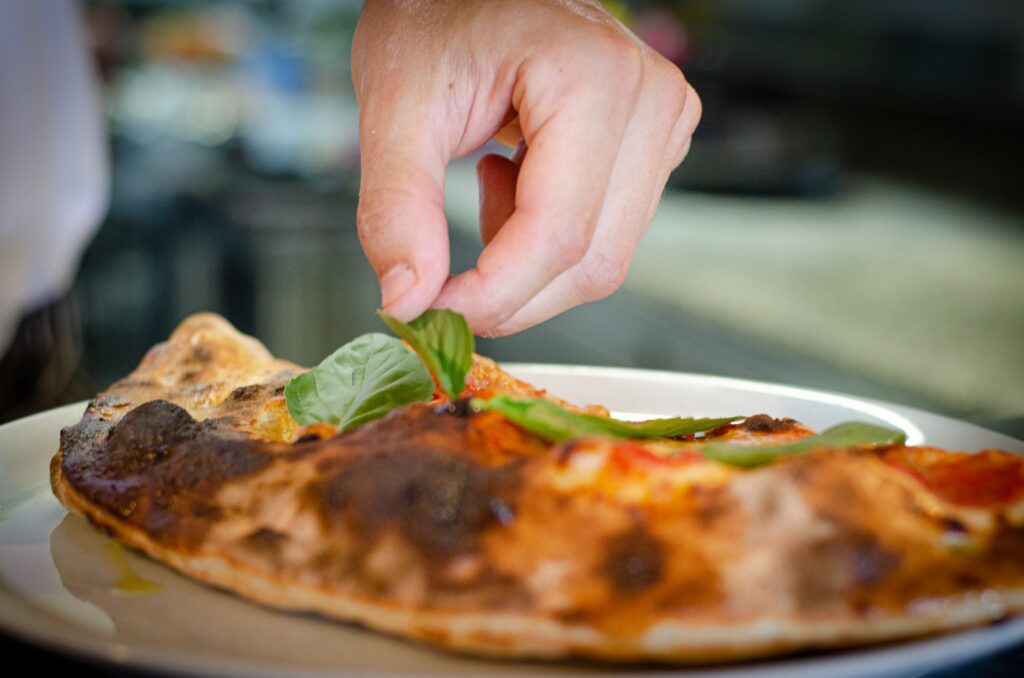 A thin-crust pizza topped with a medley of fresh vegetables, including sliced tomatoes, bell peppers, onions, and mushrooms, all smothered in gooey melted cheese.