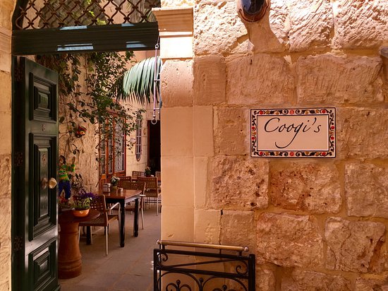 The inviting ambiance of Coogi's restaurant, featuring rustic decor and soft lighting, sets the stage for diners to savor authentic Sicilian vegan cuisine amidst a cozy atmosphere in Mdina.