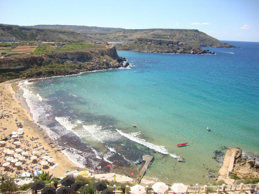 Golden Bay: A stunning stretch of golden sand meeting the azure waters of the Mediterranean under a clear blue sky.