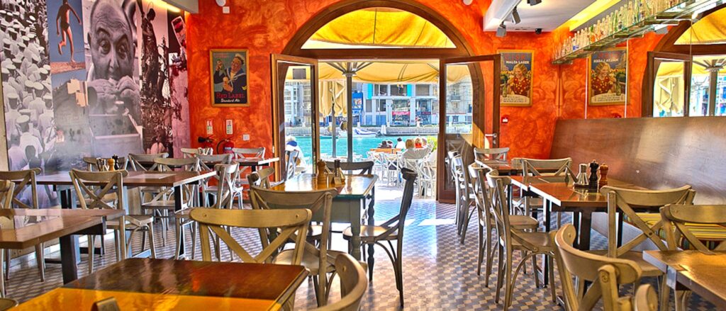 The welcoming atmosphere of Gululu restaurant, with its cozy ambiance and traditional Maltese charm, invites diners to enjoy a delightful array of naturally vegan sides and tapas, offering a taste of authentic local flavors in a relaxed setting.