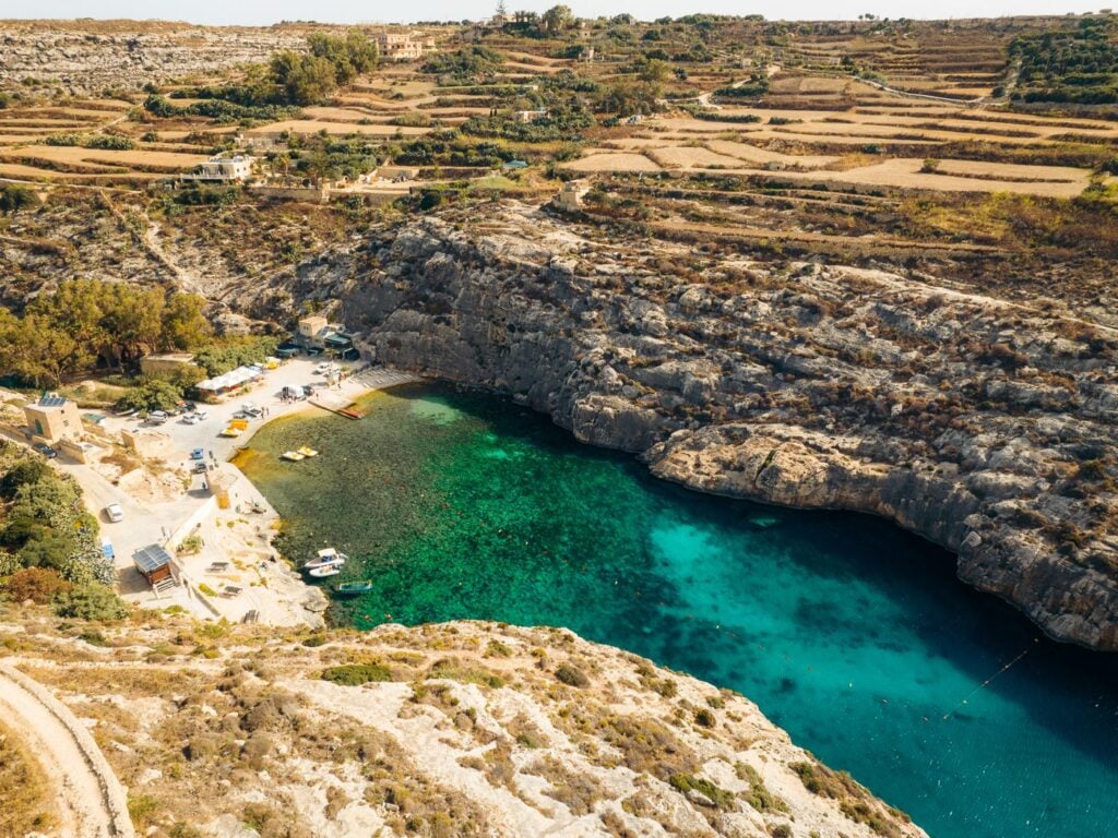 Mġarr ix-Xini, Gozo: A scenic inlet with rocky cliffs surrounding clear blue waters, showcasing the natural beauty of Gozo's coastline.