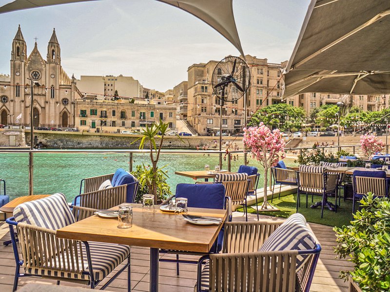 The captivating views from NAAR Restobar, overlooking Valletta's picturesque skyline, offer a stunning backdrop as diners enjoy a delectable vegan breakfast, immersing themselves in the vibrant atmosphere of Malta's capital city.