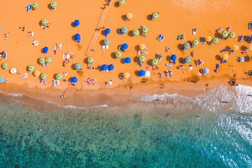 Ramla Bay, Gozo: A stunning view of the terracotta-colored sandy beach of Ramla Bay, surrounded by lush greenery and bathed in golden sunlight.