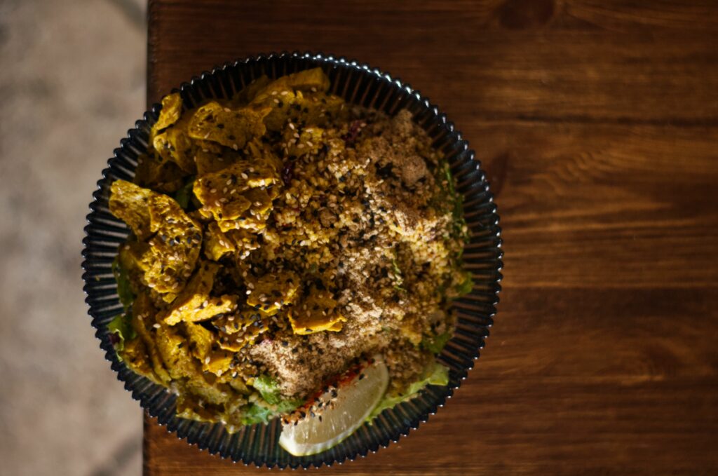 A bowl featuring fluffy quinoa mixed with diced vegetables, topped with vibrant greens and a sprinkle of seeds.