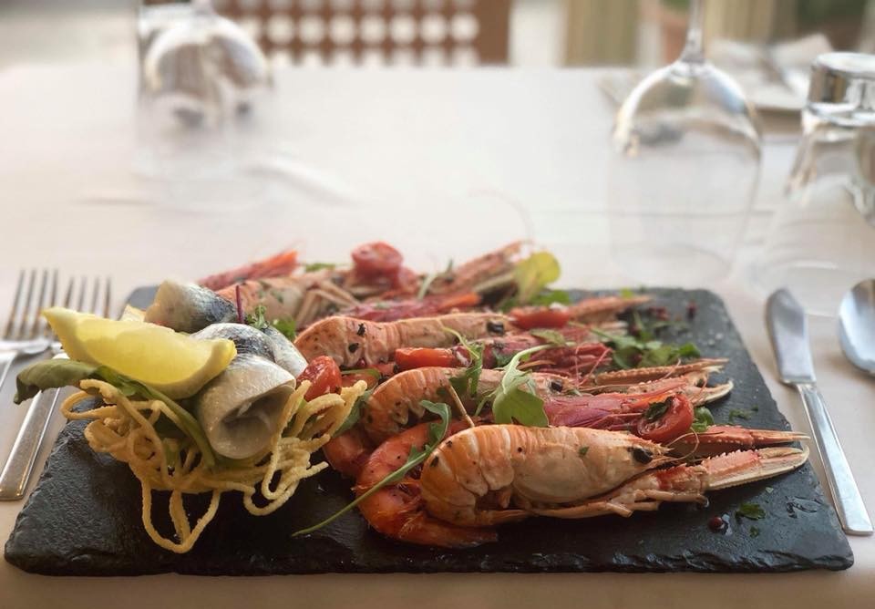 A delectable plate of king prawn pasta served at Enchante Restaurant in Senglea, Malta. The dish features al dente pasta tossed in a creamy garlic sauce, accompanied by plump king prawns, cherry tomatoes, and fresh herbs. The vibrant colors and enticing aroma of the dish evoke a sense of indulgence and culinary delight, inviting diners to savor every flavorful bite against the backdrop of the restaurant's elegant ambiance.