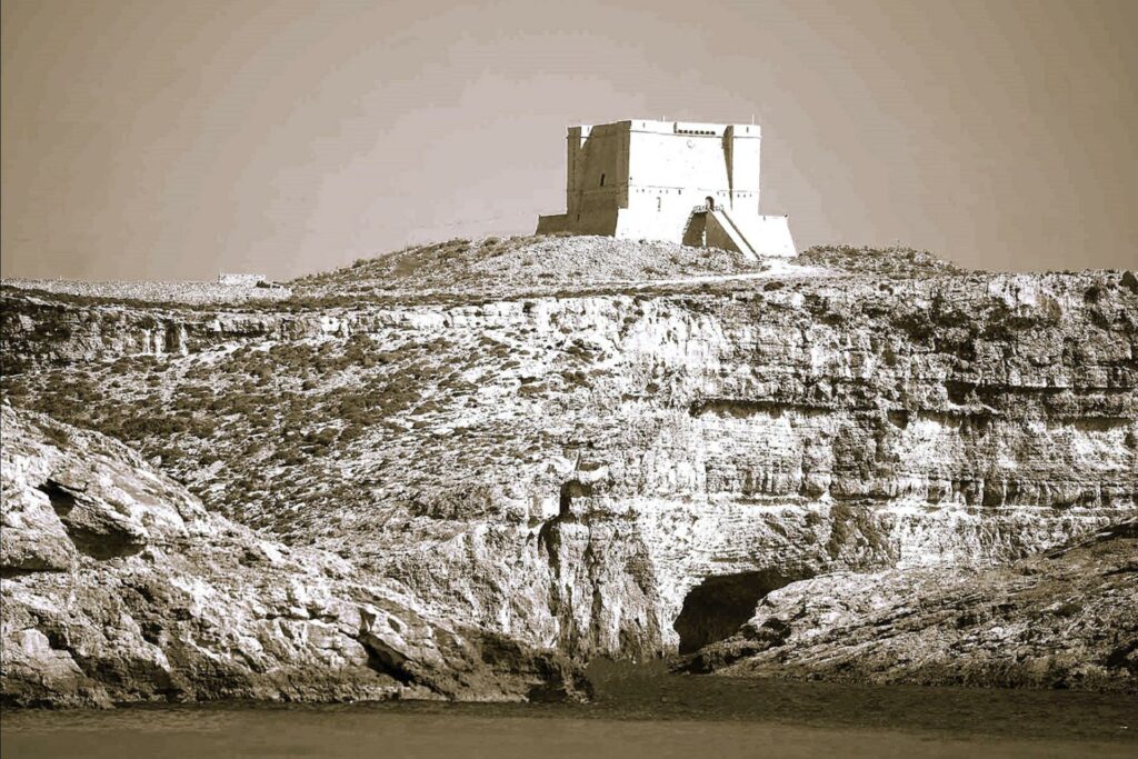 Historic Comino Watchtower: The historic St. Mary’s Tower on Comino Island, Malta, standing tall with its stone walls and offering panoramic views of the surrounding sea and landscape.