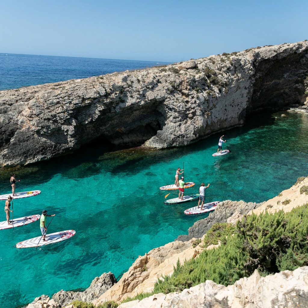 Local Gozo scene featuring picturesque countryside, traditional Maltese architecture, and a stunning view of the sea.