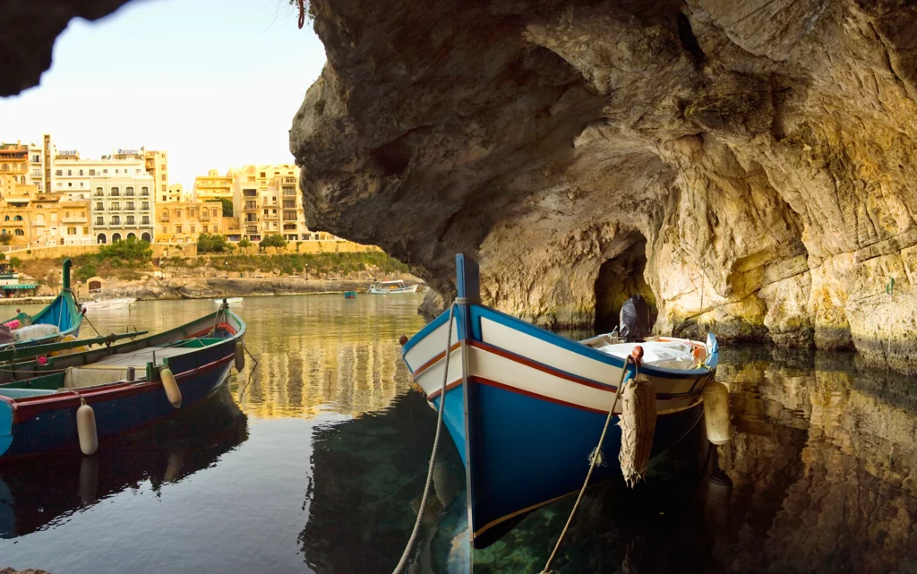 Local Gozo scene featuring picturesque countryside, traditional Maltese architecture, and a stunning view of the sea.