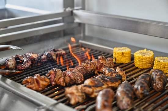 Scenic view of one80 restaurant in Gozo, featuring a barbecue platter with a variety of seafood, overlooking the marina.