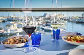 Scenic view of one80 restaurant in Gozo, featuring a barbecue platter with a variety of seafood, overlooking the marina.