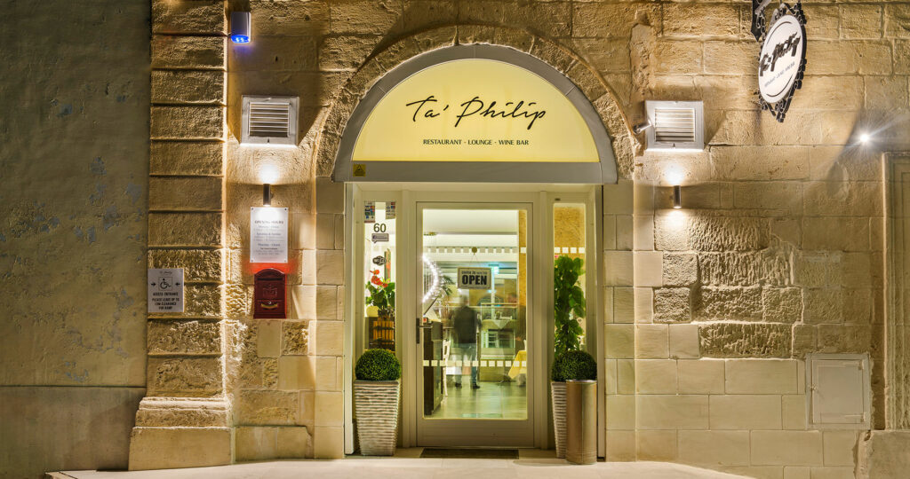 Entrance and interior view of Ta' Philip restaurant in Gozo, showcasing a delectable seafood plate.